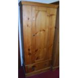 A stained pine single door wardrobe, having single long lower drawer, w.82cm
