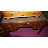 An early 20th century figured walnut and gilt tooled green leather inset kneehole writing table,