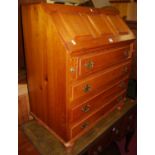 A modern pine slopefront four-drawer writing bureau, raised on turned squat supports, w.77cm