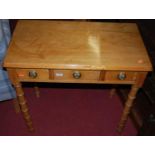 A Victorian stained pine round cornered three drawer side table, raised on bamboo effect supports,