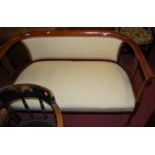 A late Victorian mahogany and cream floral upholstered three piece Bergere suite, comprising; two