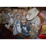 A collection of eight various modern porcelain standing dolls, each clothed, having fixed eyes,