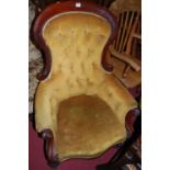 A mid-Victorian mahogany show frame gentlemans spoonback armchair, upholstered in mustard fabric,