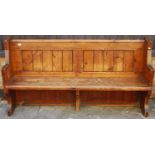 An early 20th century stained and panelled pine four-seater church pew, h.165cm