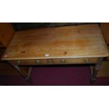 A Victorian pine round cornered two drawer side table raised on turned suppors, width 110cm