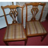 A set of four mahogany Chippendale style dining chairs, each having striped fabric upholstered