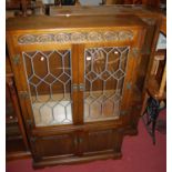 A contemporary Old Charm moulded oak and double door lead glazed bookcase, having twin linenfold