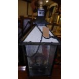 A black pained cast metal and glass inset hanging paraffin lantern, of good size, having hinged door