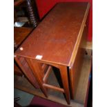 A 1960s teak dining suite comprising; drop-leaf table with gate leg action, and a set of four