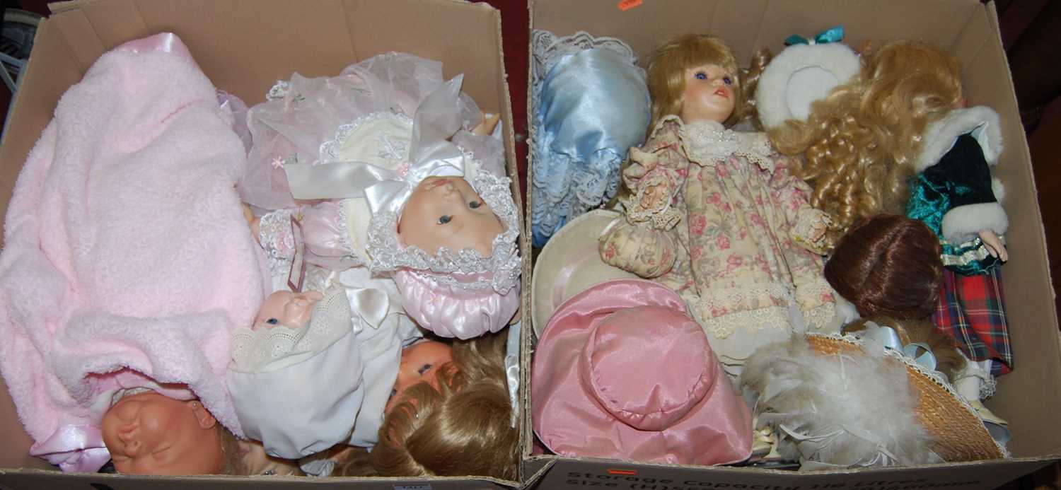 Two boxes containing a large quantity of modern porcelain dolls, all fully clothed, some with