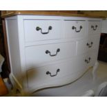 A contemporary French style beech and part white painted serpentine front chest, of six various