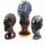 An African carved hardwood head of a man, height 25cm, together with another similar example, and