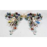 A pair of German floral encrusted porcelain wall brackets decorated with putti, 20th Century, 22cm