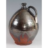 An early 19th century earthenware bellamine jug, of typical form, having silver lustre drip glaze,