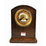 An early 20th century oak cased mantel clock, the gilt chapter ring showing Arabic numerals, eight
