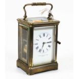 An early 20th century lacquered brass cased carriage clock, having an enamelled dial with Roman