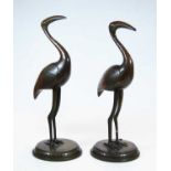 A pair of 20th century Indian brass models of birds, each standing on a circular plinth, height