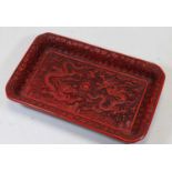 A Chinese export red cinnabar lacquer tray, of rectangular form, the centre profusely carved with