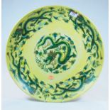 A Chinese export yellow glazed charger, decorated with a five claw dragon to the centre within a
