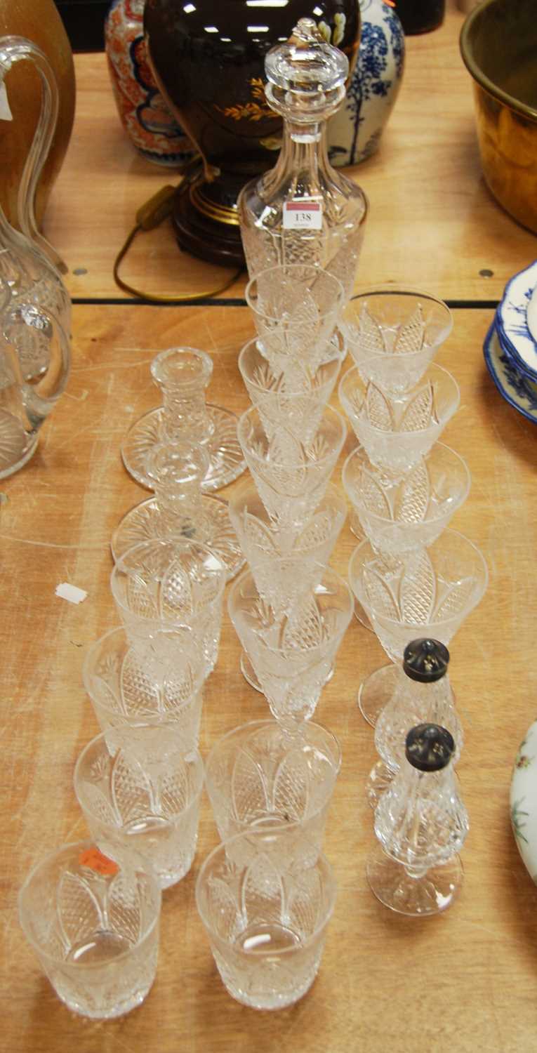 A collection of glassware to include a cut glass decanter, candlesticks, and various drinking