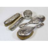 A late Victorian five-piece silver mounted dressing table set, each piece relief decorated with a