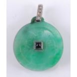 An Art Deco jade disc pendant, incised to either side with simplistic Chinese symbols and centre set