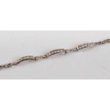 A white metal diamond line bracelet, featuring three curved bars each channel set with five round