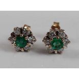 A pair of 9ct yellow and white gold emerald and diamond circular cluster earrings, each with a