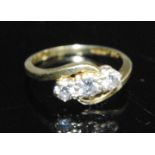 An 18ct yellow gold diamond crossover style three-stone ring, comprising three graduated round