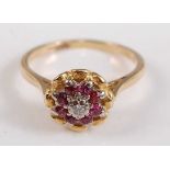 A yellow and white metal, ruby and diamond reverse circular cluster ring, with centre round