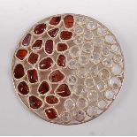 A large sterling silver circular abstract pendant, having 22 polished garnet pieces and 35 rock