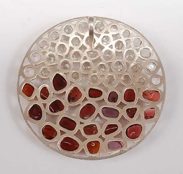 A large sterling silver circular abstract pendant, having 22 polished garnet pieces and 35 rock - Image 2 of 2