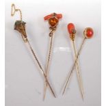 A collection of four late 19th century stick pins, comprising: a yellow metal shield shaped stick