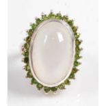 A white metal, moonstone and diopside oval cluster ring, featuring an oval moonstone cabochon within