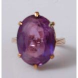 A 9ct yellow gold and synthetic purple sapphire ring, the oval synthetic sapphire in a six-claw
