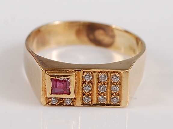 A yellow metal rectangular signet ring, the head set with one rectangular cut ruby and 11 round