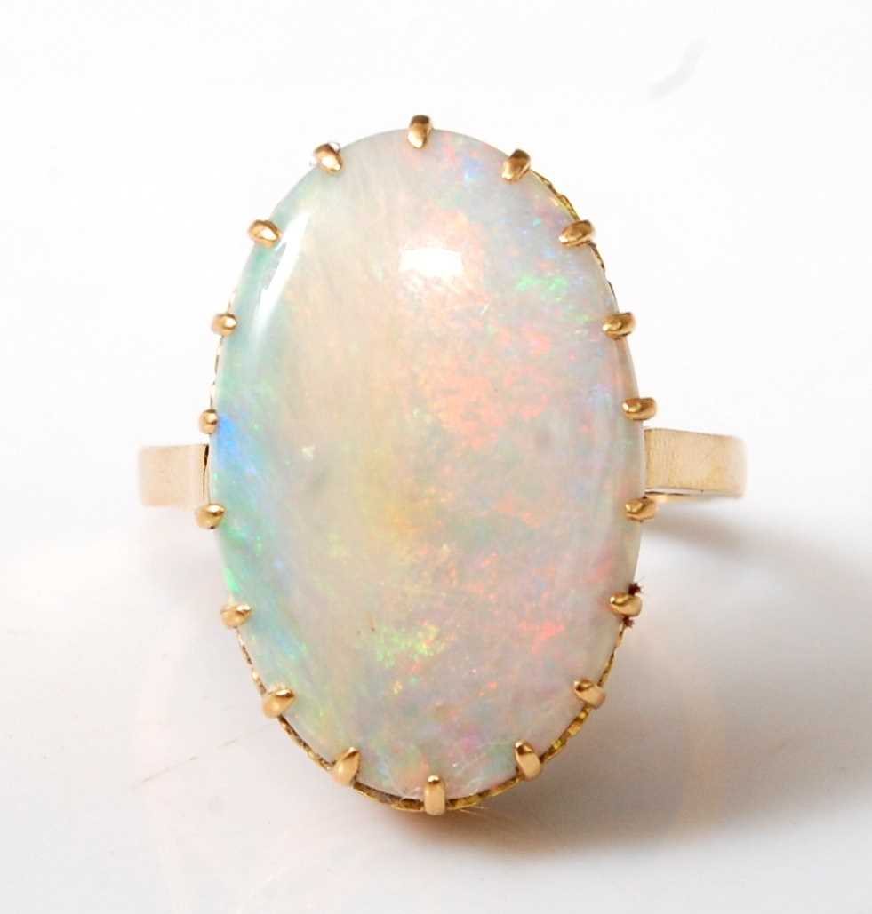 An 18ct yellow gold oval opal dress ring, the cabochon cut opal measuring approx 20.2 x 13.0 x 3.