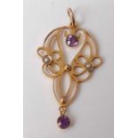 An Edwardian yellow metal openwork amethyst and seed pearl pendant, the two round amethysts