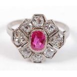 A white metal, ruby and diamond Art Deco style lozenge shaped cluster ring, featuring a centre