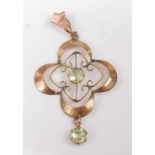 An Edwardian yellow metal openwork shamrock style pendant, having a round peridot to the centre