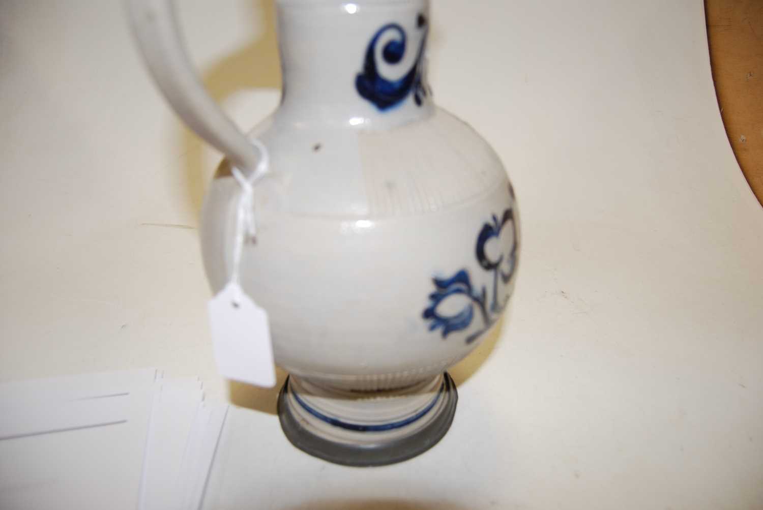 A German Westerwald stoneware jug, with pewter lid and thumb rest decorated in blue with a crucifix, - Image 6 of 14