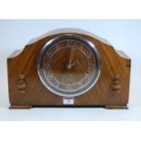 A 1930s walnut cased mantel clock, the chapter ring showing Arabic numerals, eight day movement with