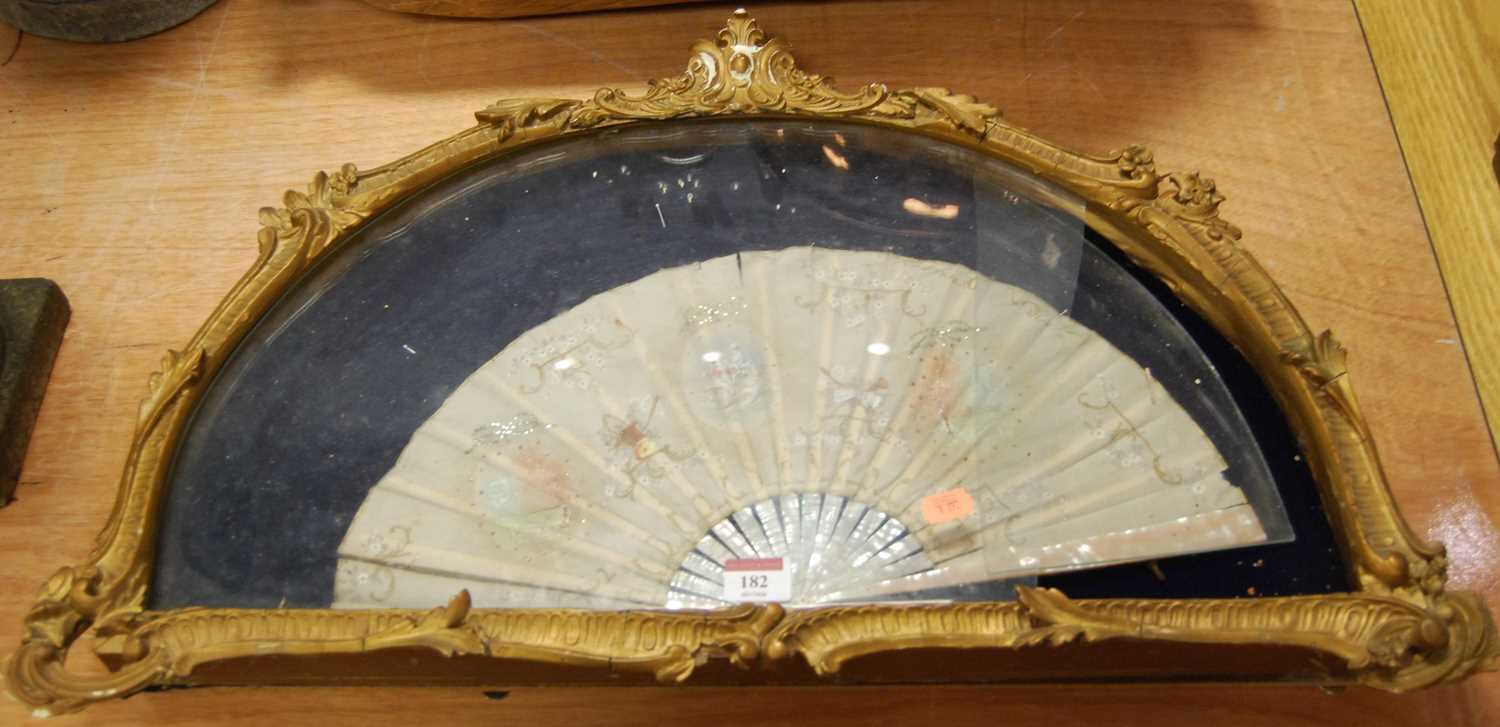 A 19th century silk and mother of pearl fan, painted with figures, flowers and C scrolls, housed