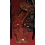 A large tribal style wall mask together with a Burmese carved occasional table, a carved hardwood