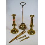A collection of brassware to include a doorstop, pair of candlesticks, two paperknives, and a