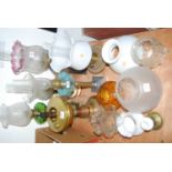 A collection of Victorian and later oil lamps and various lamp shades