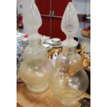 A pair of large glass pharmacy/chemist display jars, pear shaped, standing on circular foot, 77cm