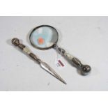 An oversized magnifying glass with mother of pearl handle, together with a matching letter opener (