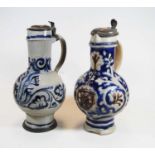 A German Westerwald stoneware jug, with pewter lid and thumb rest decorated in blue with a crucifix,