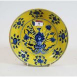 A Chinese export yellow and blue glazed porcelain dish, decorated with a lotus to the centre, six